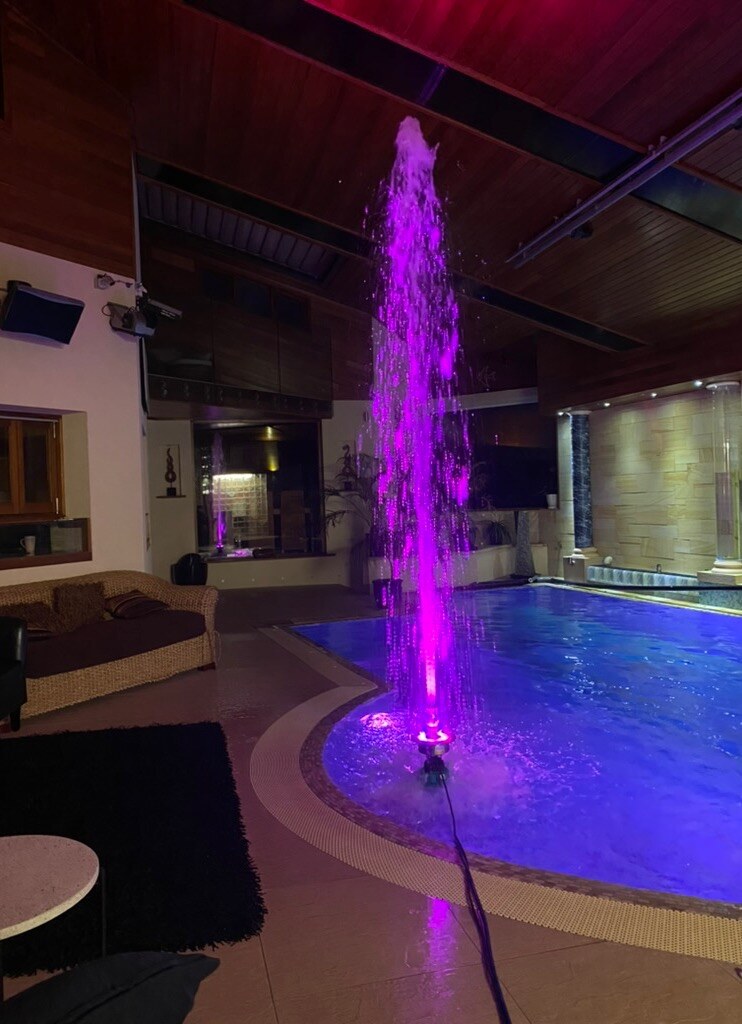 IZEP Fountain producing a tall RGB illuminated water column in an indoor pool